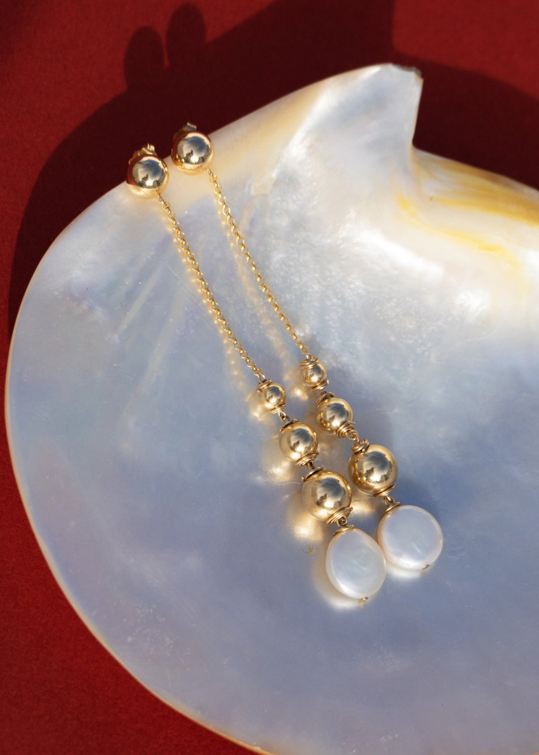 Gold-Filled earrings featuring shiny gold beads and a gemstone