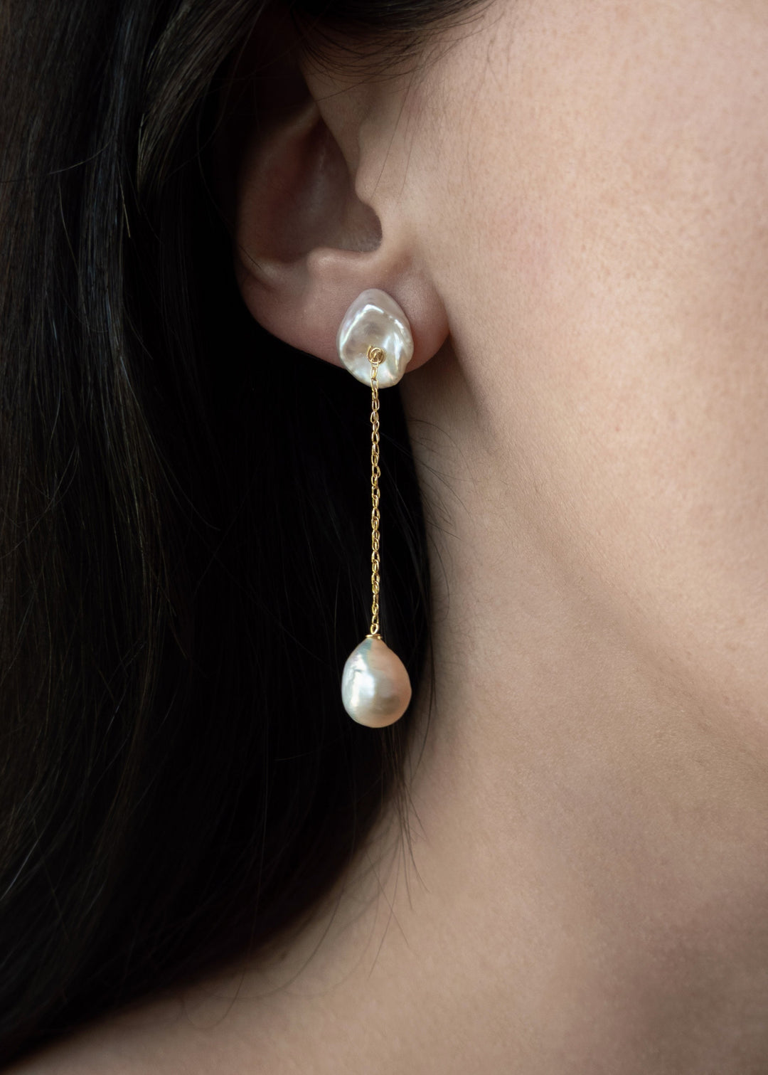 Alba - The top of these earrings features two keshi pearls shaped like conch shells, offering a unique and textured focal point. From each, a delicate rope chain drapes down to light pink baroque pearls, creating a graceful, understated design that highli
