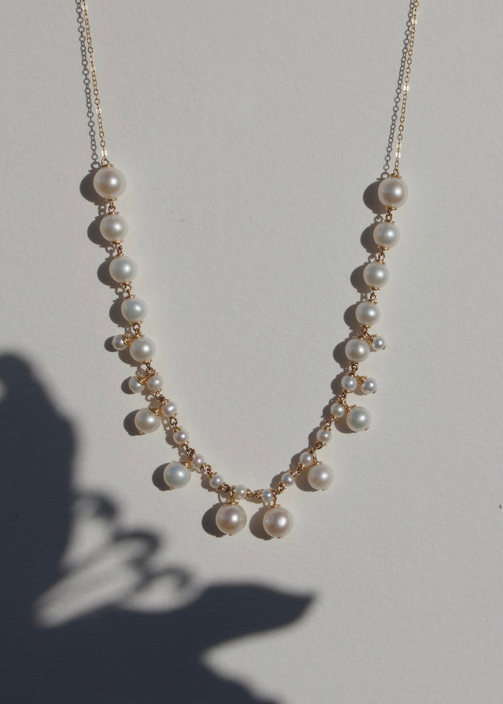 Alora - Graduated pearls flow from large to small, with delicate drops that mirror the pattern in reverse. The Alora necklace feels regal yet effortless, a modern take on classic pearl design. 14K Gold-Filled Tarnish-Resistant &amp; Hypoallergenic AAA Grade G