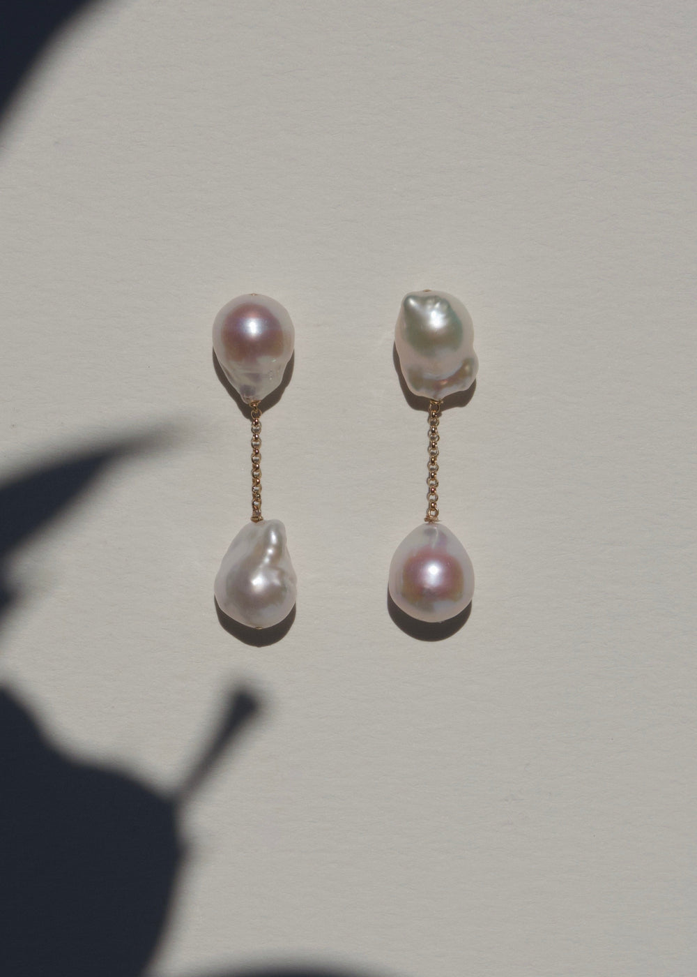 Anya earrings on a light wall with plant shadow