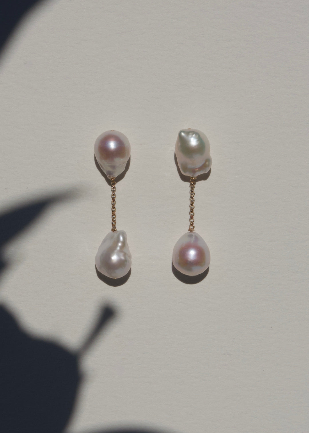 Anya earrings on a light wall with plant shadow