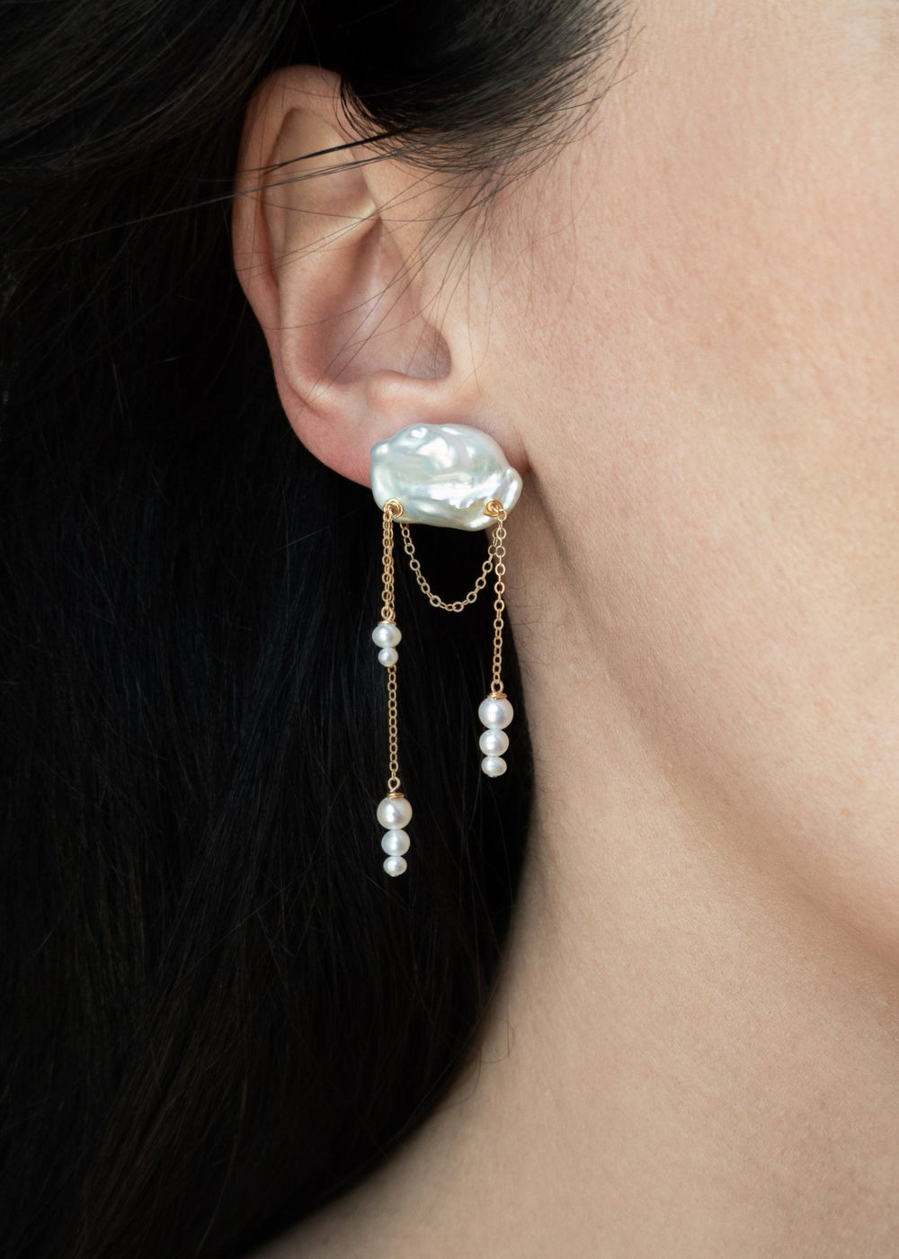 Aurora - These asymmetrical earrings feature cascading seed pearls hanging from cloud like keshi pearls. Suspended from a reflective cable chain, their unique design balances elegance and movement in a strikingly modern way. 14K Solid Gold Freshwater Kesh