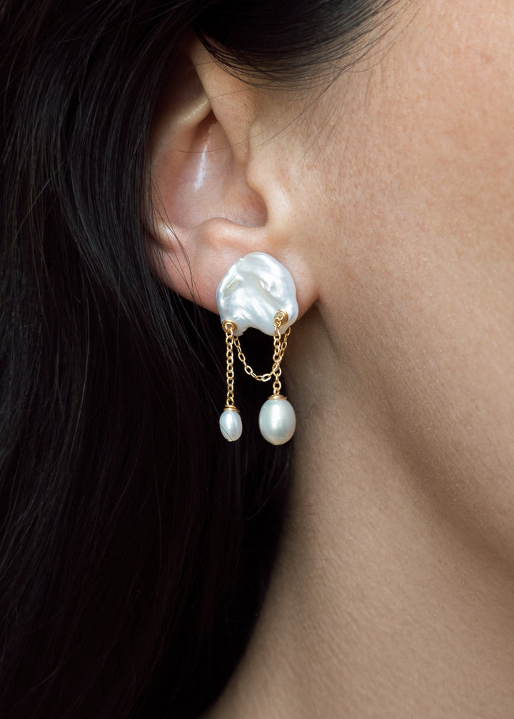 Aven - Small in scale but full of charm, these earrings bring a playful touch to a refined silhouette. Short gold chains sway softly from petite pearls, creating just enough movement to catch the eye. Delicate, feminine, and easy to wear, these are the ki