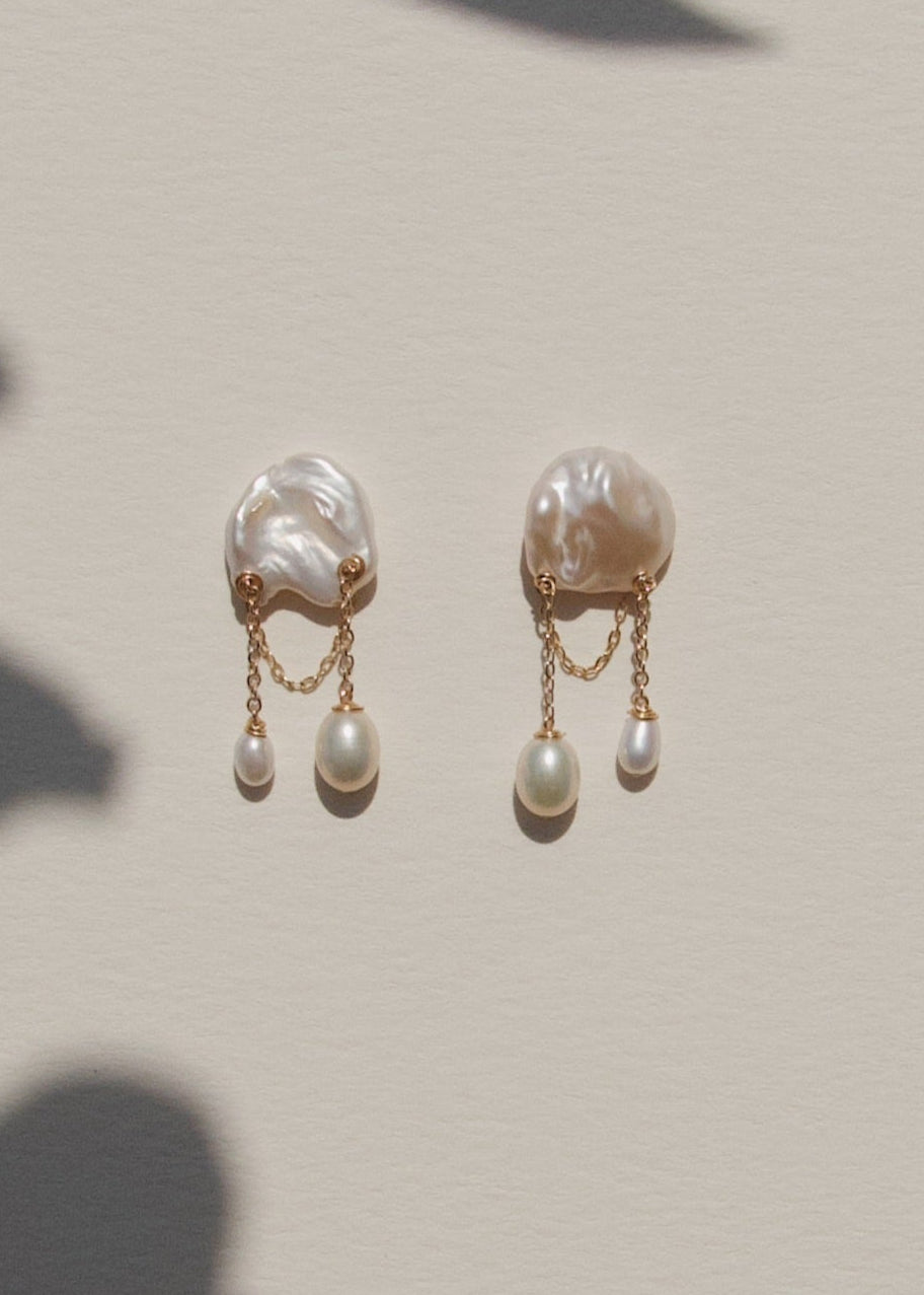 Aven - Small in scale but full of charm, these earrings bring a playful touch to a refined silhouette. Short gold chains sway softly from petite pearls, creating just enough movement to catch the eye. Delicate, feminine, and easy to wear, these are the ki