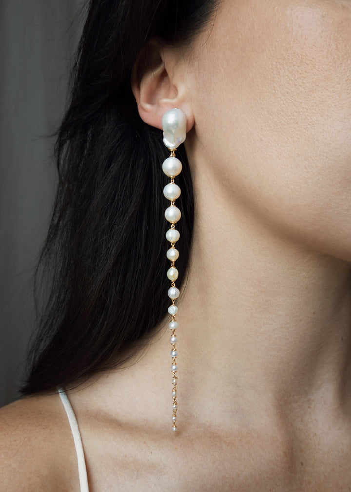 Azalea - Crafted with baroque pink or white pearls that taper into delicate white seed pearls, these earrings are a bold blend of femininity and edge. Striking in every sense, they command attention with their unexpected silhouette. 14K Gold-Filled Tarnis