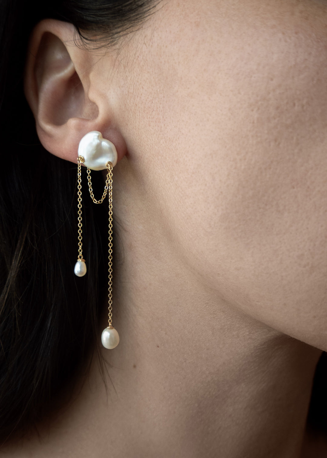 Bria - A single keshi pearl anchors this delicate design, with two fine strands falling at varied lengths. Between them, a single gold chain is draped like a quiet detail you almost missed. Graceful and understated, it’s a perfect choice for a wedding or