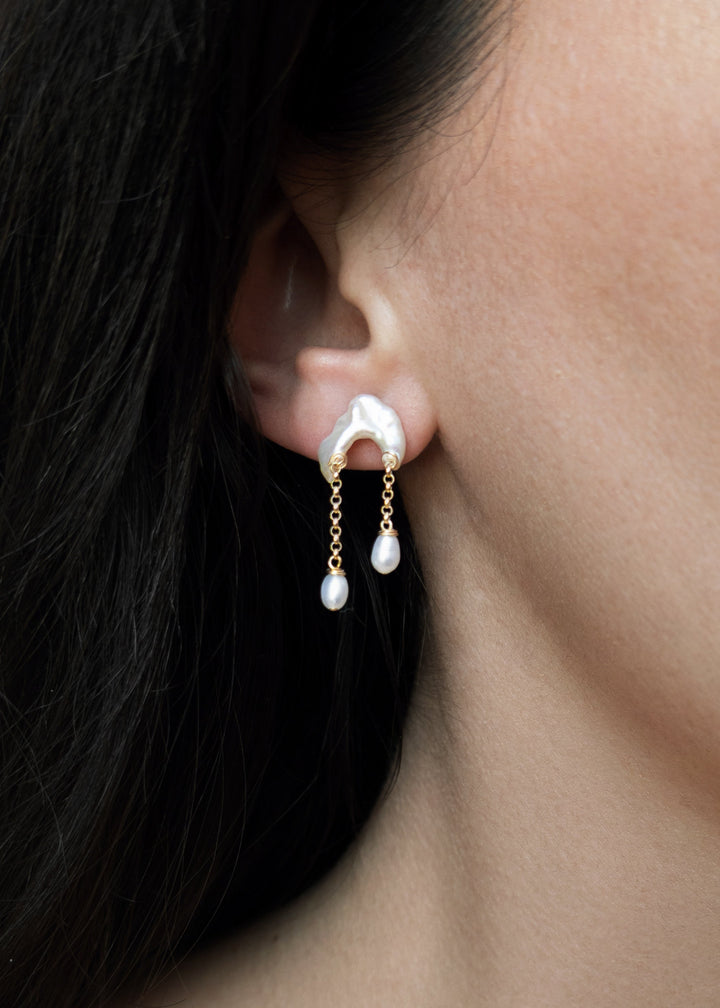 Bridges - Inspired by the natural arches carved into coastal cliffs, these earrings echo the quiet strength of time and tide. Asymmetrical keshi pearls form soft, irregular bridges, each one unique, with subtle curves and texture. From beneath them, rolo