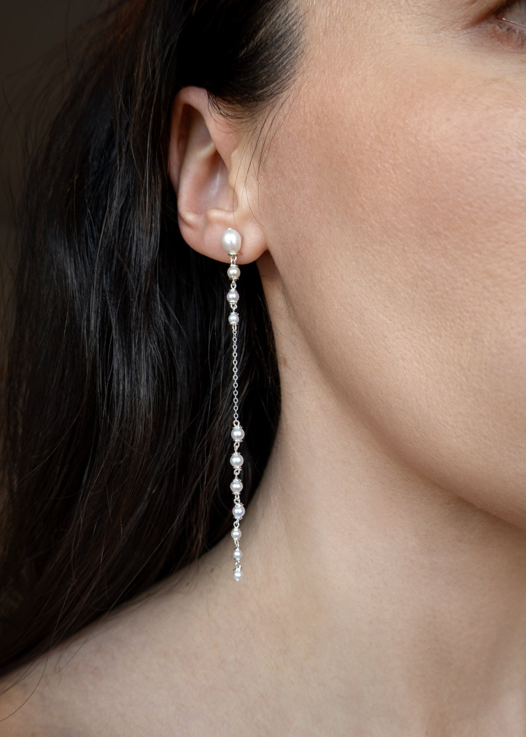Dahlia - A gentle cascade of seed pearls creates a tapering effect that feels almost weightless. Designed to drape across two piercings the silhouette is delicate, but far from simple. Each pearl moves with quiet intention, catching the light like raindro