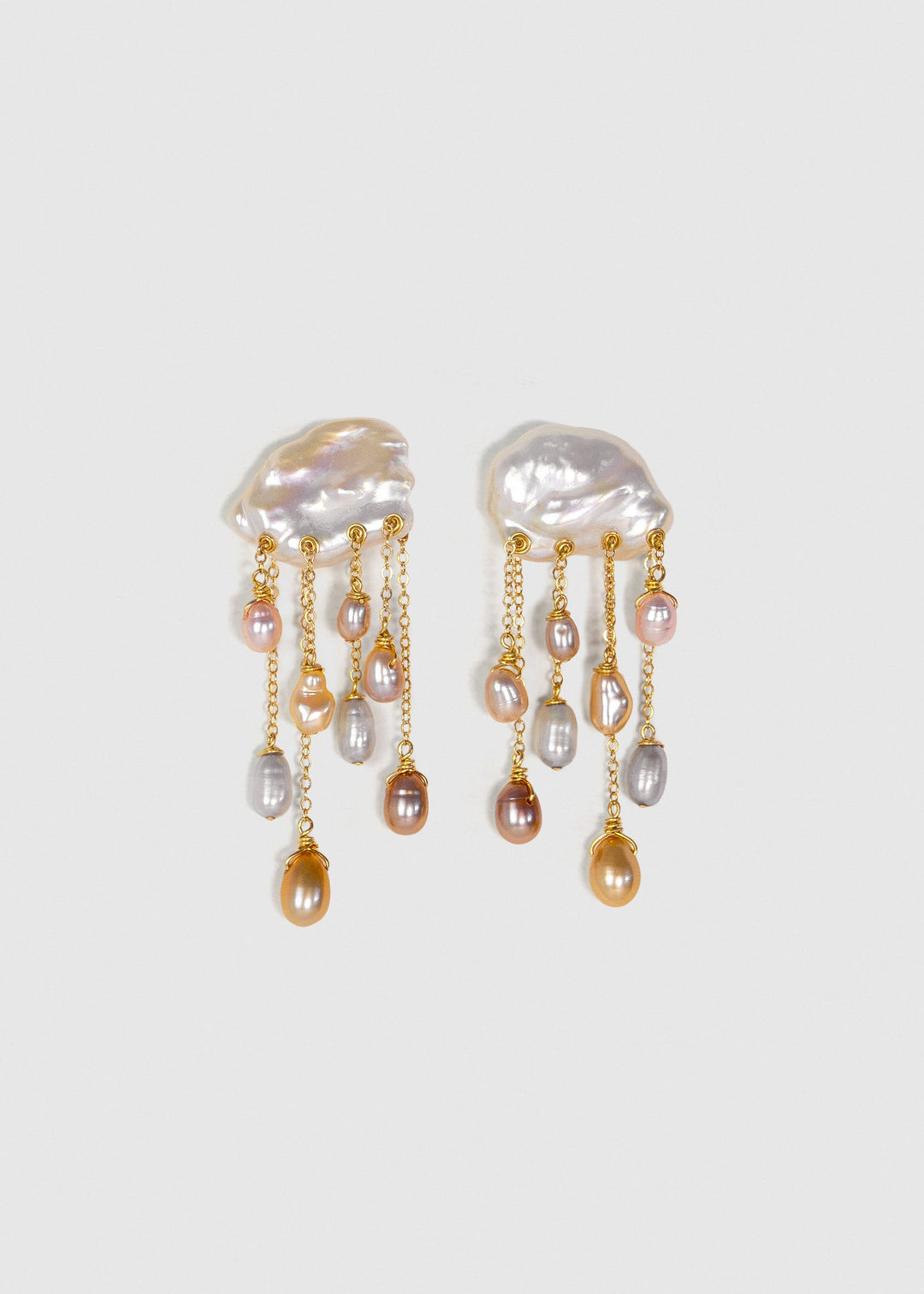 Daydream 14k gold earrings with irregular freshwater keshi pearl tops and cascading multicolored teardrop pearls on a light background.