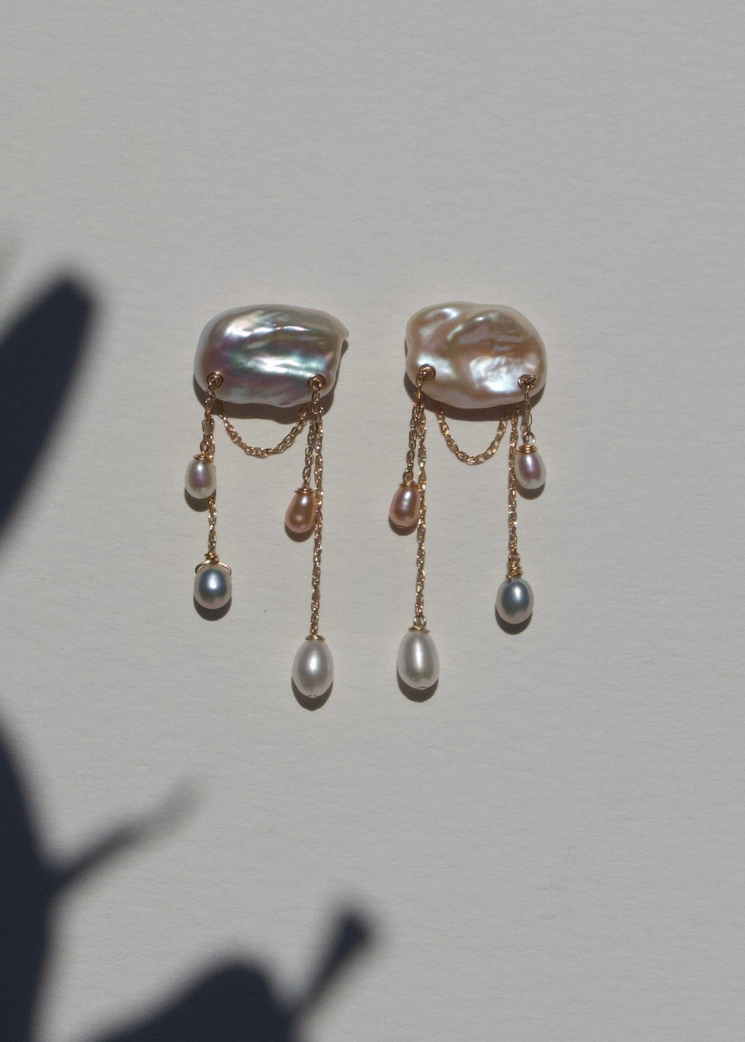 Dove earrings on a light wall with plant shadow