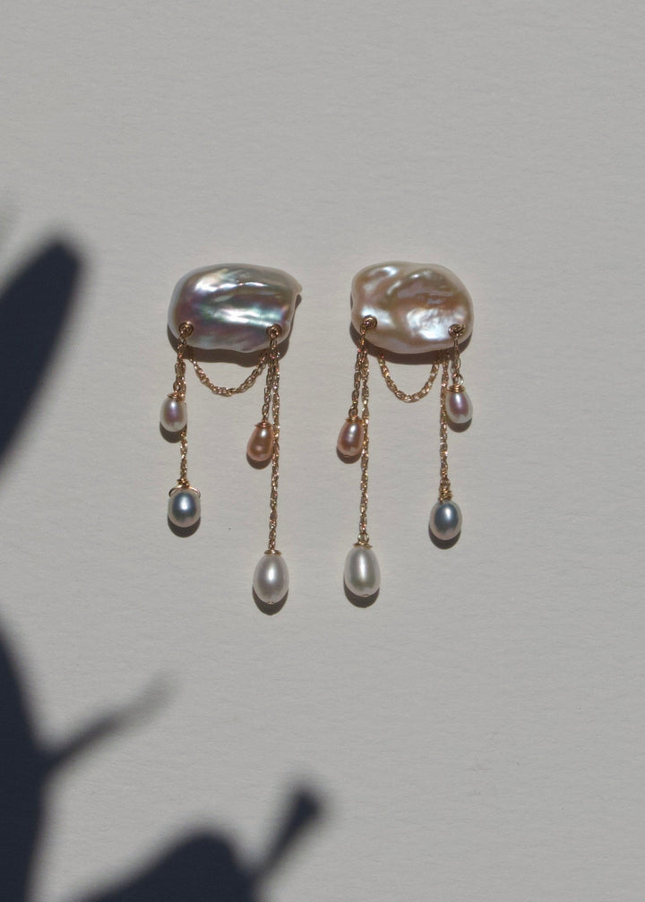 Dove earrings on a light wall with plant shadow