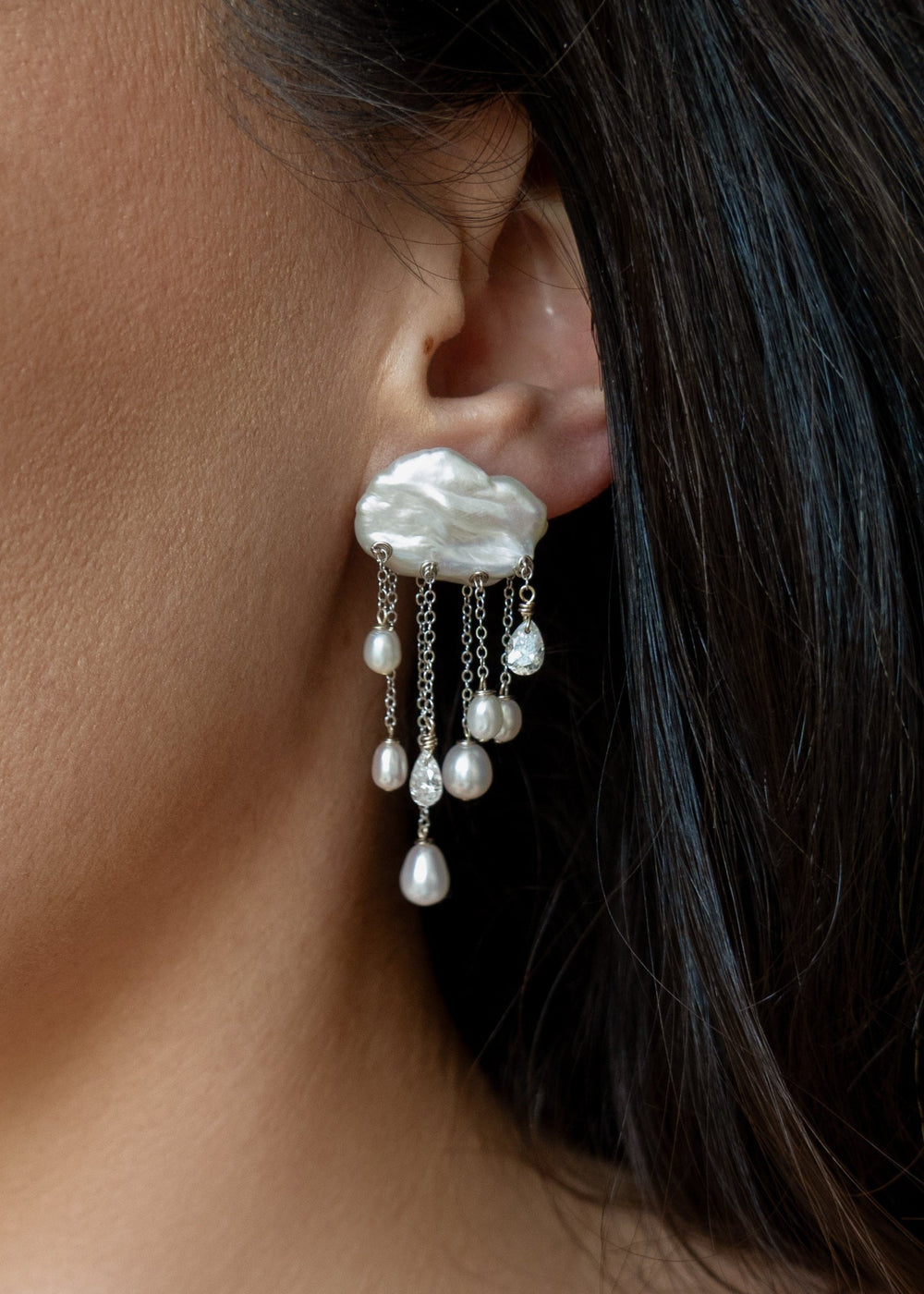 Model wearing a Halo 14k white gold earring with a white keshi pearl top and dangling white teardrop pearls and diamonds.