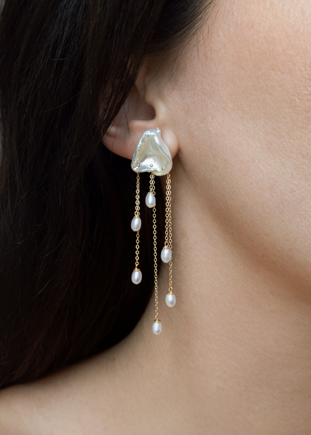 Inez - Two luminous keshi pearls anchor these earrings, imperfect in shape, yet perfectly matched. Their sculptural forms and 14k gold chains create a balanced silhouette that feels both refined and untamed. Delicate, dramatic, and made to frame the face