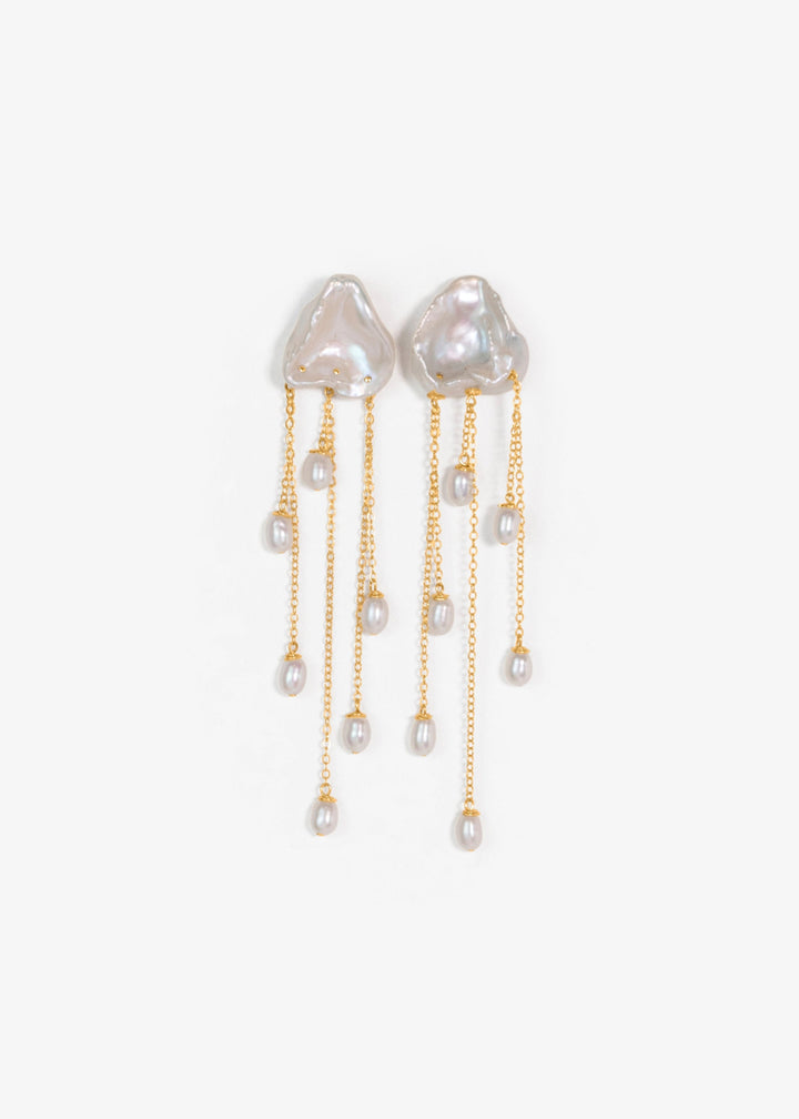 Inez - Two luminous keshi pearls anchor these earrings, imperfect in shape, yet perfectly matched. Their sculptural forms and 14k gold chains create a balanced silhouette that feels both refined and untamed. Delicate, dramatic, and made to frame the face