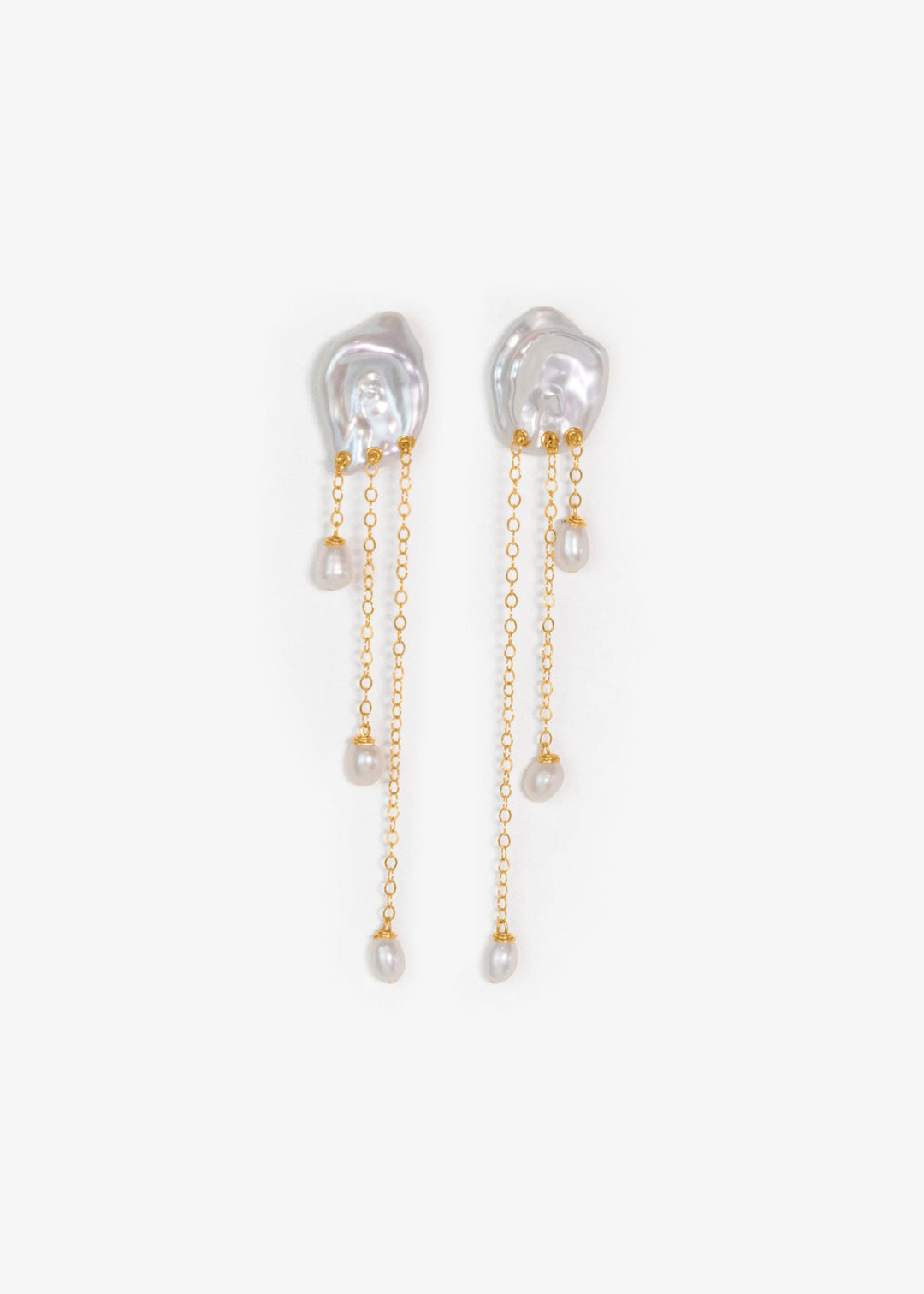 Laguna - These keshi pearls ripple like water touched by a falling drop soft, fluid, and full of light. Suspended below, three 14k gold chains fall at varying lengths, cascading like a quiet stream. Reflective and refined, they bring a sense of calm movem