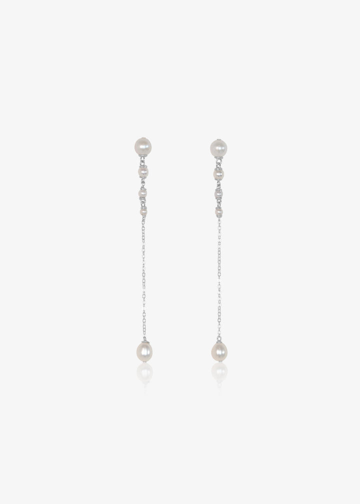 Lucine Earrings - Three inches of effortless elegance. These earrings feature pearls that flow from larger to smaller, ending in a single teardrop pearl. Suspended from a reflective chain, the Lucine Earrings pair beautifully with the Lucine Necklace for