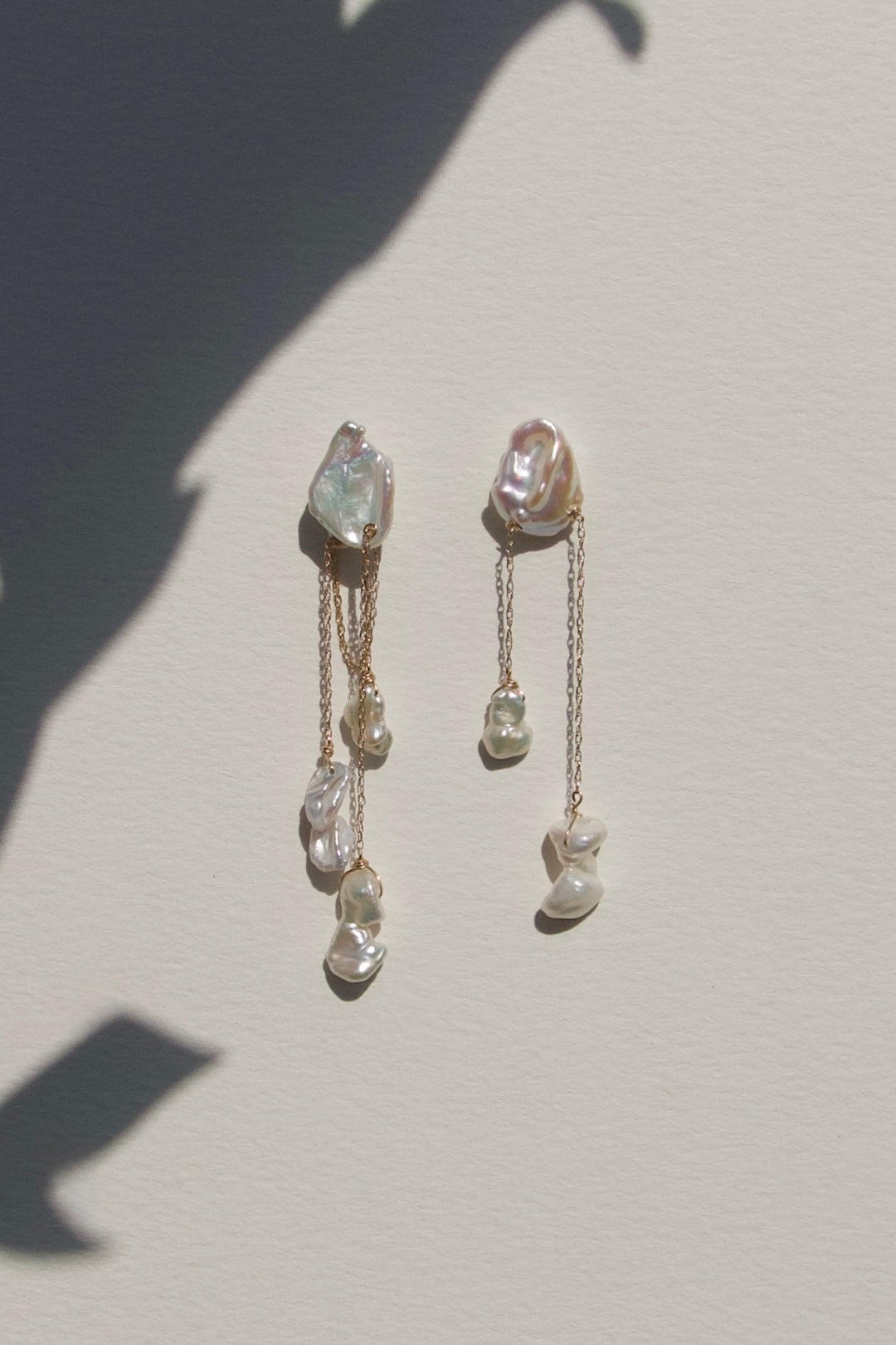 Pair of gold earrings with gemstones on a light gray background