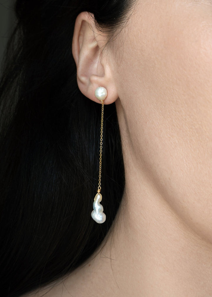 Nova - These asymmetrical earrings feature a crescent-shaped pearl on one side, evoking the delicate curve of the moon. Dainty chains hang from each end, with a teardrop pearl dangling at the bottom, creating an elegant design that balances softness and c