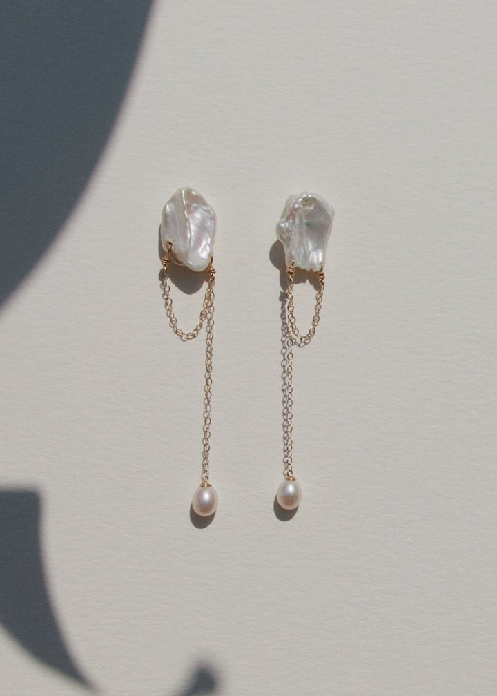 Oasis - These earrings feature two unique keshi pearls with a bold, chunky cable chain draped from each, creating a modern contrast. A single teardrop pearl completes the design, adding a delicate touch to the striking silhouette. 14K Solid Gold Freshwate