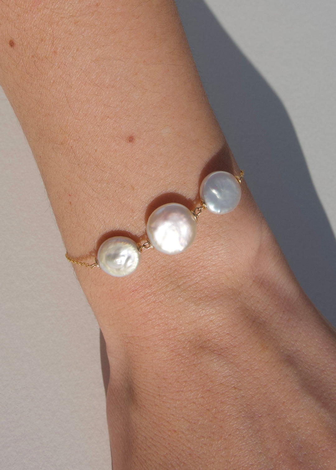 Roselle Bracelet - Three luminous coin pearls, one large at the center and two smaller pearls sit on its side. The Roselle’s clean, sculptural design makes it effortlessly chic for any occasion. 14K Gold-Filled Metals Tarnish-Resistant & Hypoallergenic AA