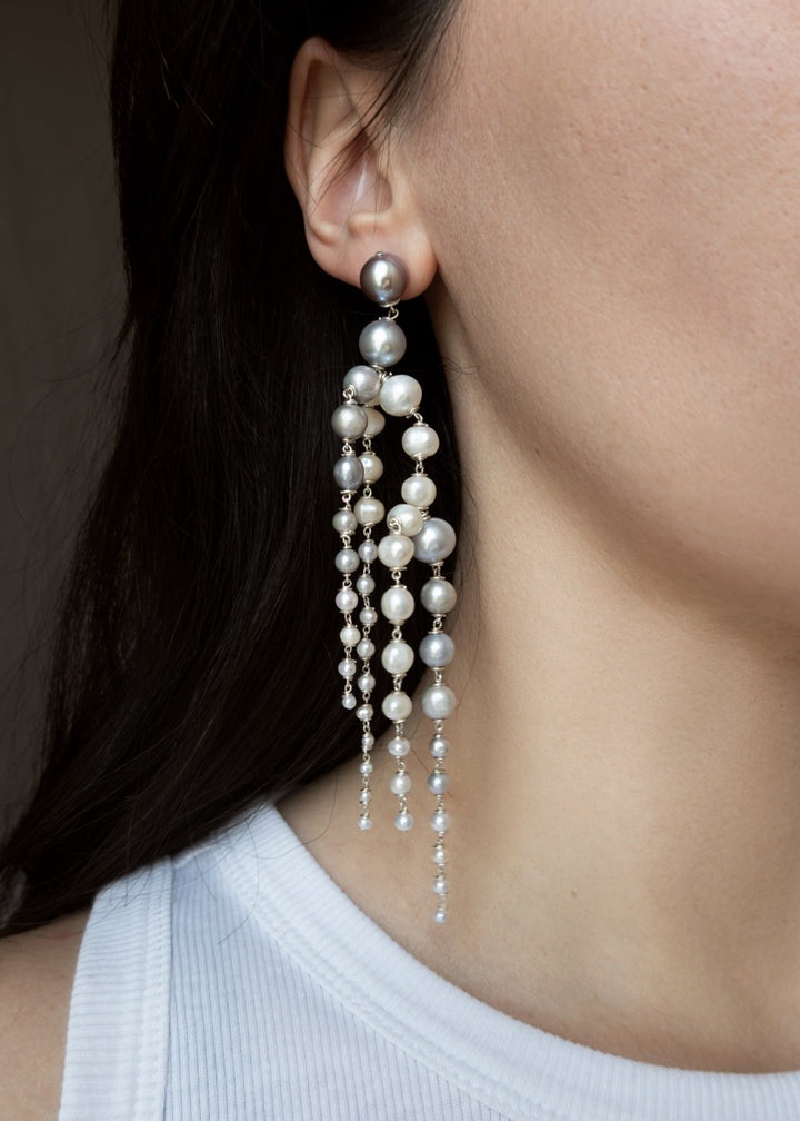 Rue - Crafted with silver pearls that gracefully taper into white seed pearls, these earrings are unlike any you’ve seen before. Striking yet soft, they sway with movement, adding an elegant touch to every look. The perfect statement piece to elevate any