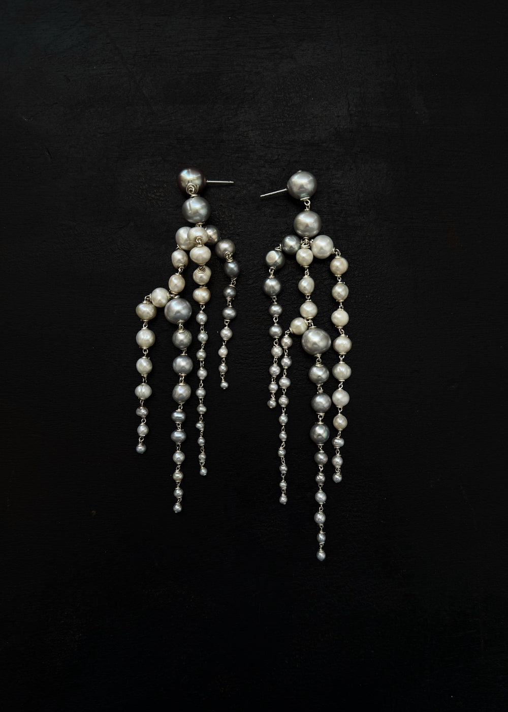 Rue - Crafted with silver pearls that gracefully taper into white seed pearls, these earrings are unlike any you’ve seen before. Striking yet soft, they sway with movement, adding an elegant touch to every look. The perfect statement piece to elevate any