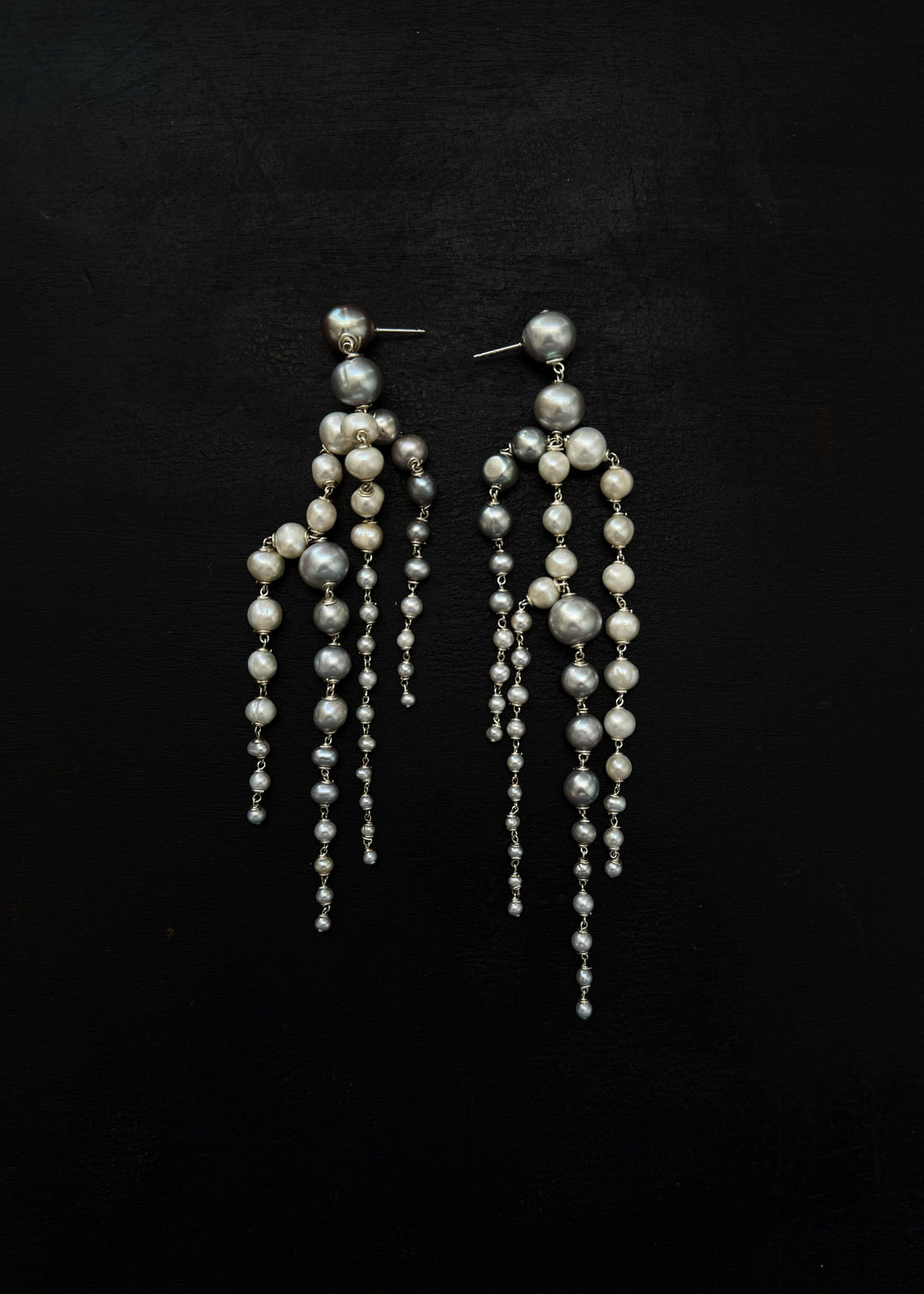 Rue - Crafted with silver pearls that gracefully taper into white seed pearls, these earrings are unlike any you’ve seen before. Striking yet soft, they sway with movement, adding an elegant touch to every look. The perfect statement piece to elevate any