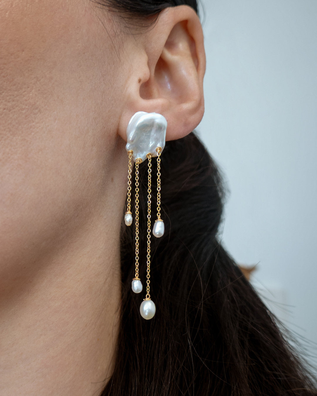 Sierra earrings worn on a model's ear, close profile