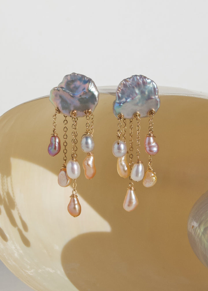 Squall - Like a sudden summer storm, the Squall earrings are full of color, movement, and quiet intensity. At the top sit two blue keshi pearls, moody and iridescent, while twelve pearls in varying tones cascade below. Vivid, sculptural, and softly dramat