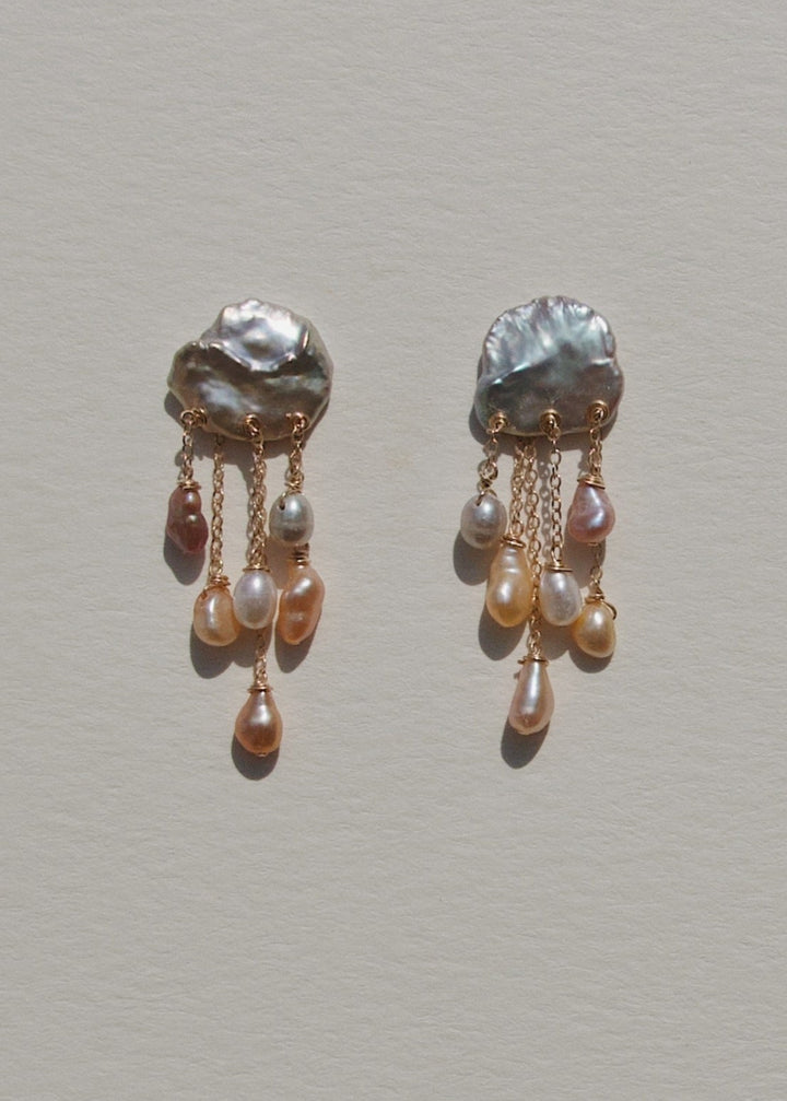 Squall - Like a sudden summer storm, the Squall earrings are full of color, movement, and quiet intensity. At the top sit two blue keshi pearls, moody and iridescent, while twelve pearls in varying tones cascade below. Vivid, sculptural, and softly dramat