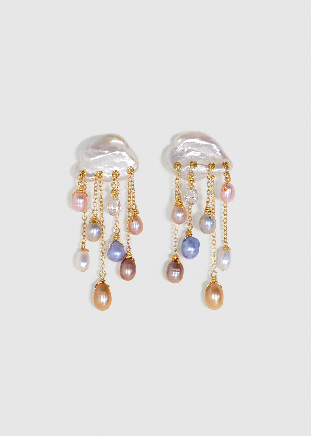 Stardust 14k gold earrings with white keshi pearl tops, colorful teardrop pearls and diamonds on cascading chains against a light background.