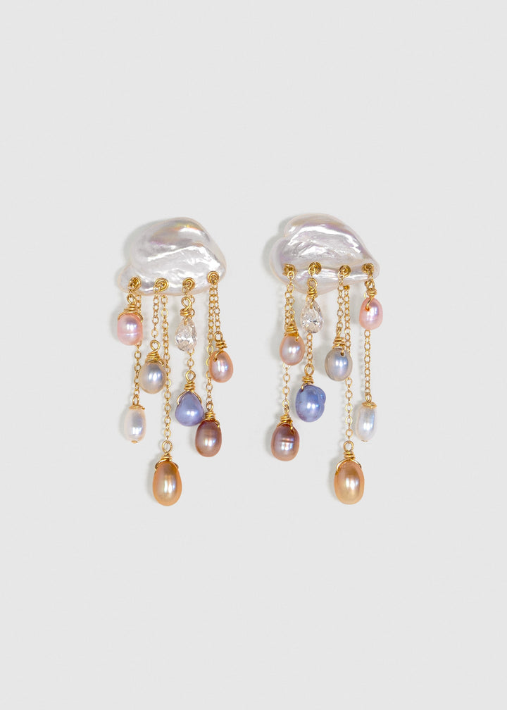 Stardust 14k gold earrings with white keshi pearl tops, colorful teardrop pearls and diamonds on cascading chains against a light background.