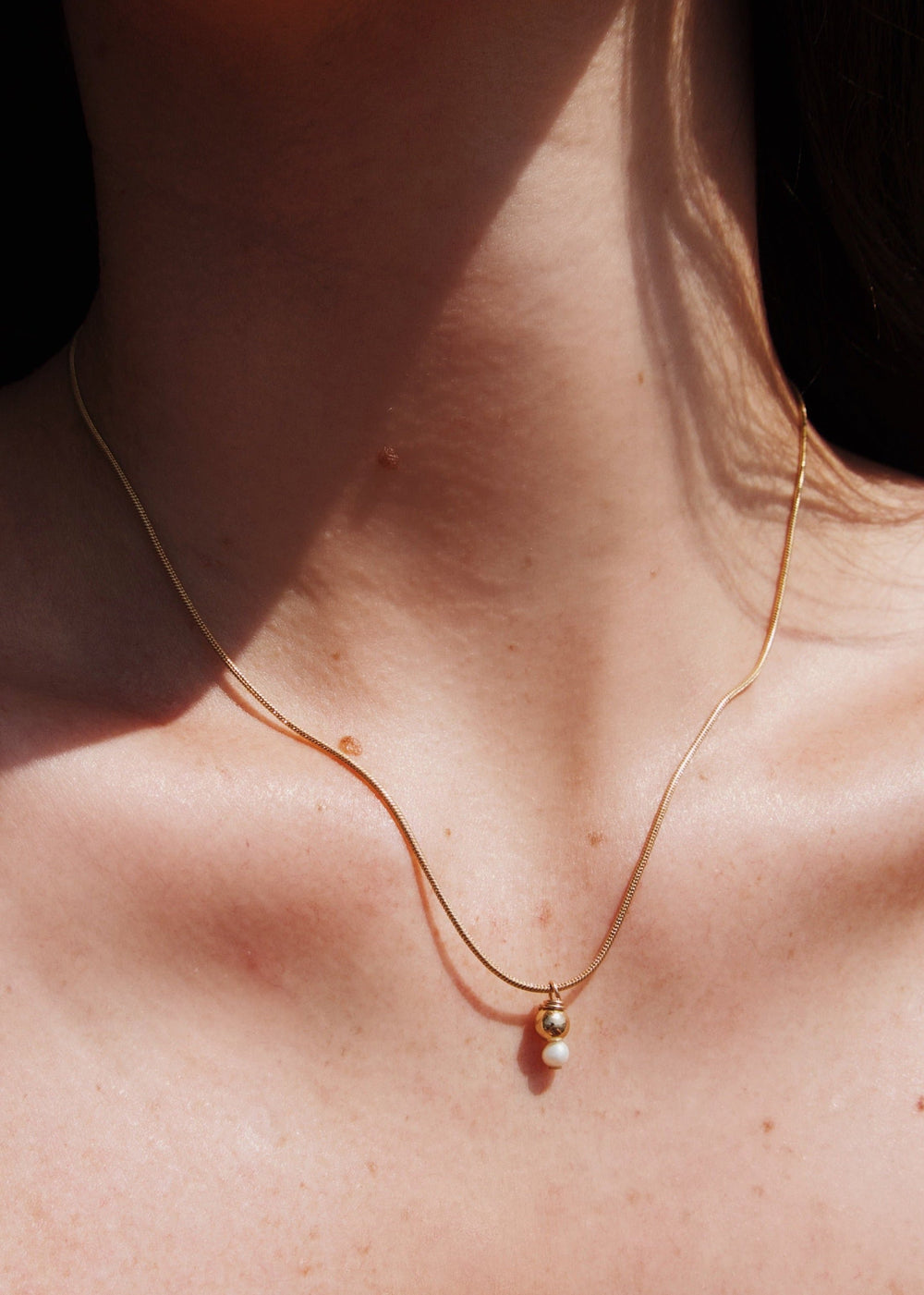 Gold-filled snake chain with a gold bead and a small pearl