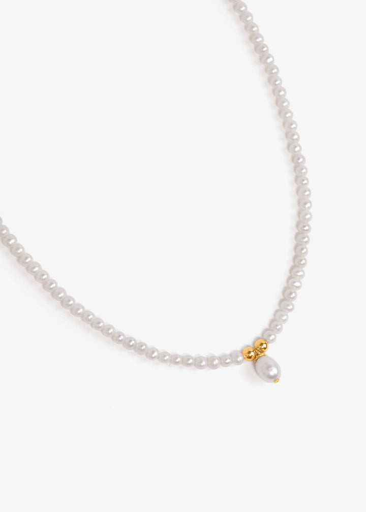 Necklace with lustrous white pearls, two gold beads and a baroque pearl