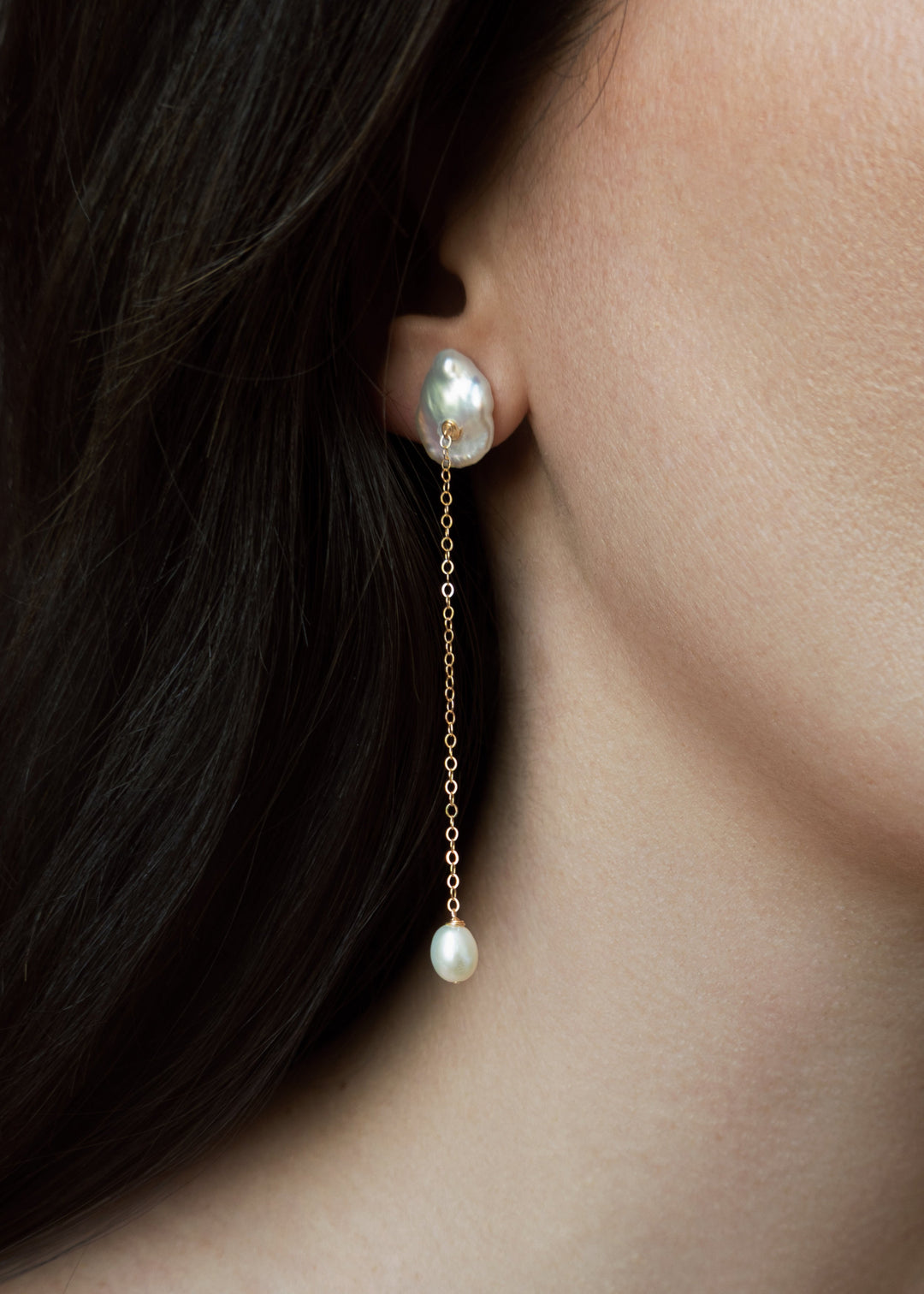 Viv - These earrings feature a single medium sized keshi pearl with a delicate 14k gold chain that falls gracefully below. At the end, a soft teardrop pearl adds a subtle glow and movement. Perfect for those who love something minimal yet distinct, especi