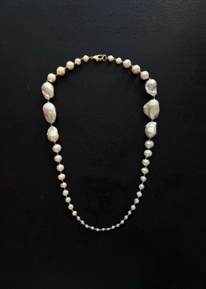Wren Necklace - A classic baroque pearl necklace — but with a bit more drama. Bold, oversized pearls at the back taper into delicate seed pearls at the front, creating an unexpected silhouette that captivates and intrigues. 14K Gold-Filled Tarnish-Resista